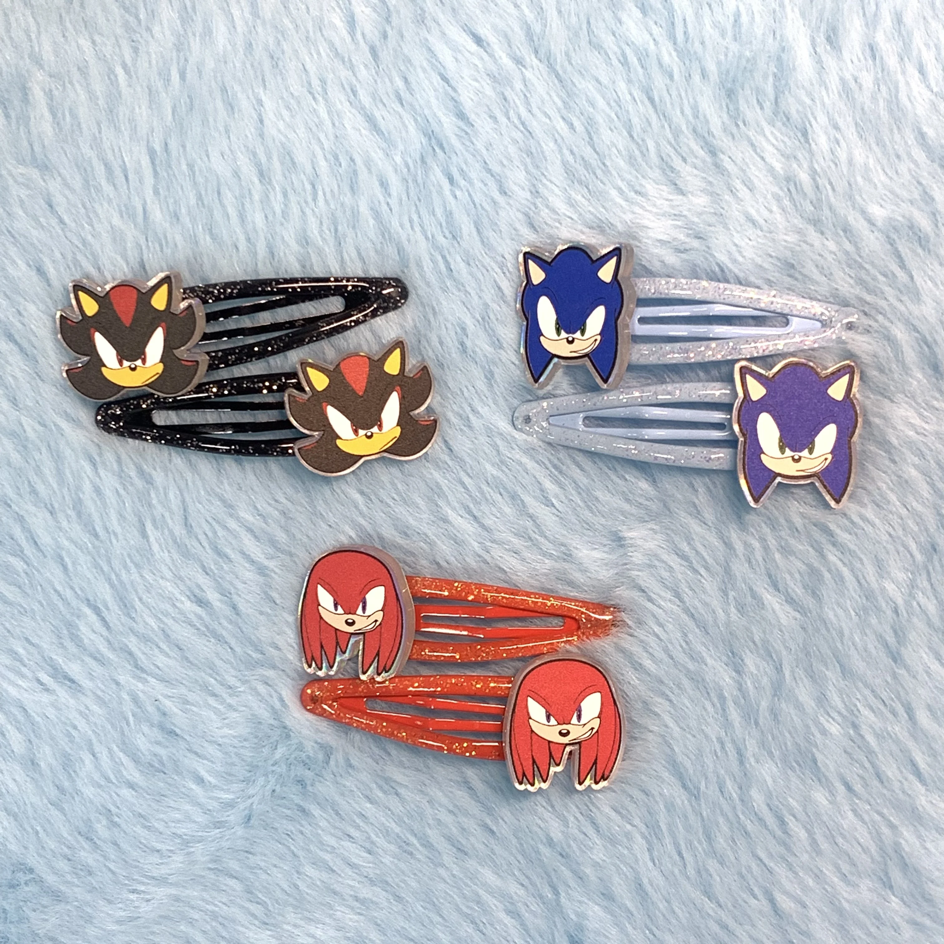 

Sonic hair clips with character designs (Sonic, Shadow, Knuckles). Glittery, cute for fans.
