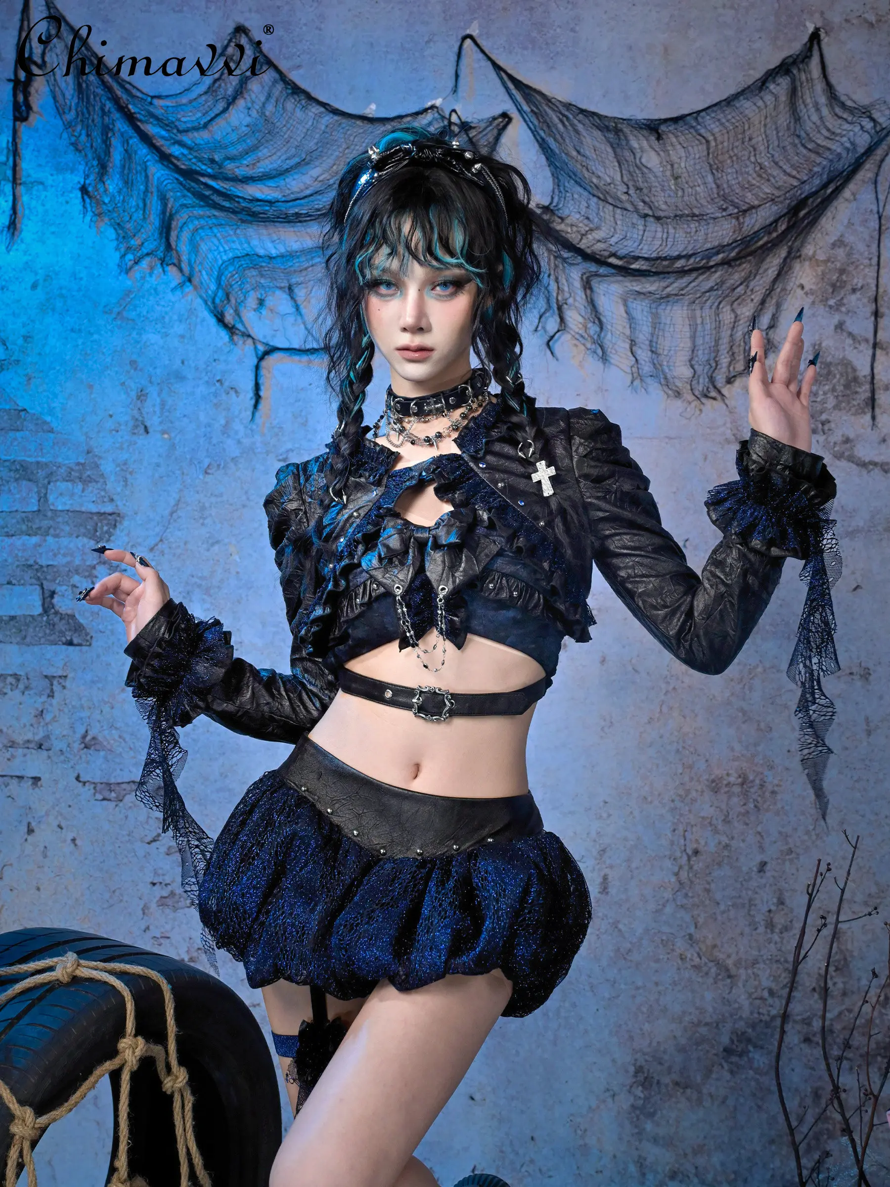 

Оригинальный панк-комплект: топ на бретелях с кружевом и блестящими цветочными бутонами, юбка с низкой талией и кольцом на бедре, укороченная куртка из искусственной кожи с рюшами. Новинка весны.