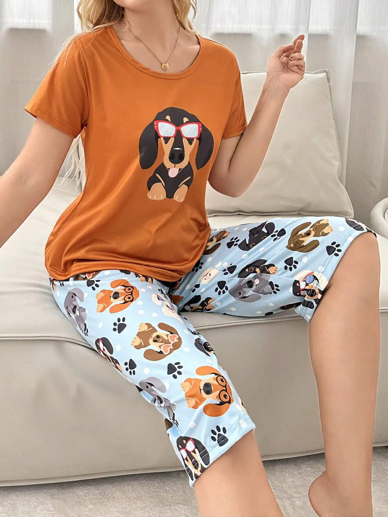 

Оранжевая футболка с графическим принтом и светло-голубой пижамный комплект с капри и принтом собаки