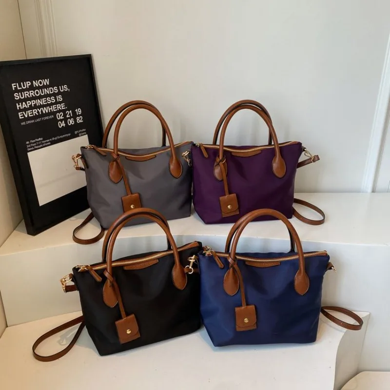 エレガントな質感のレザートートバッグ、トレンディなデザインと広々とした内装、多用途な通勤用レディースおむつバッグとしてもデザインされています。