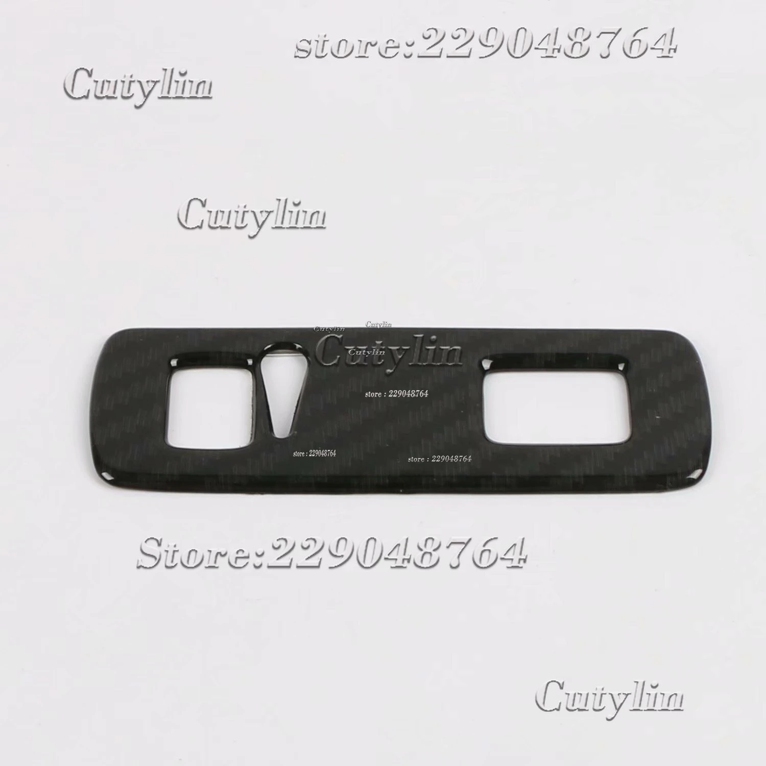Panel de moldura interior de fibra de carbono negro para Volvo XC40 2019-2021 con dos recortes rectangulares y una abertura central con forma de orificio para llave.