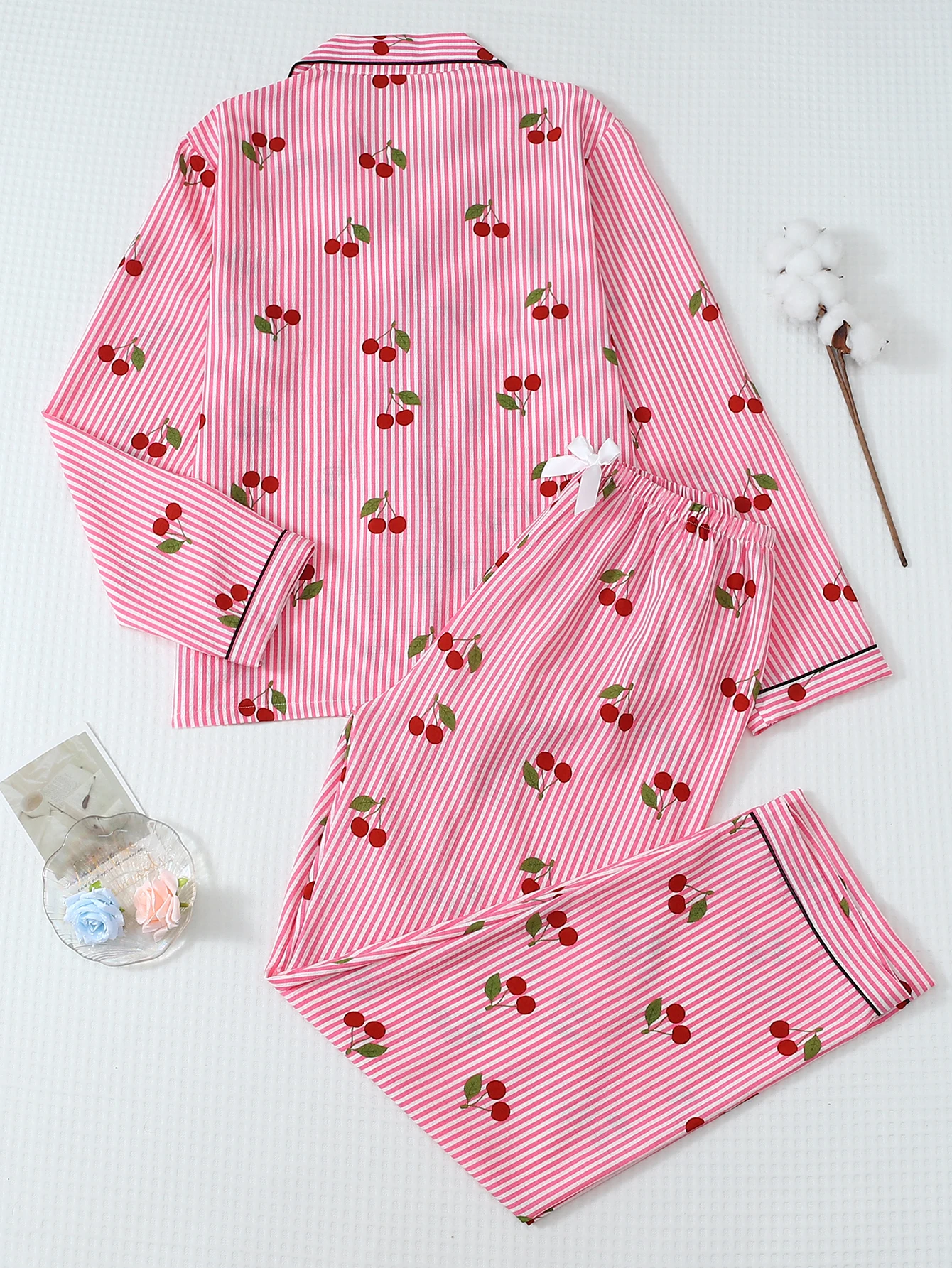 ツーピースの快適なピンクと白のストライプのチェリープリントのラペルボタンアップトップと蝶結びのロングパンツの女性用パジャマラウンジウェアセットは、家庭での使用に適しています。