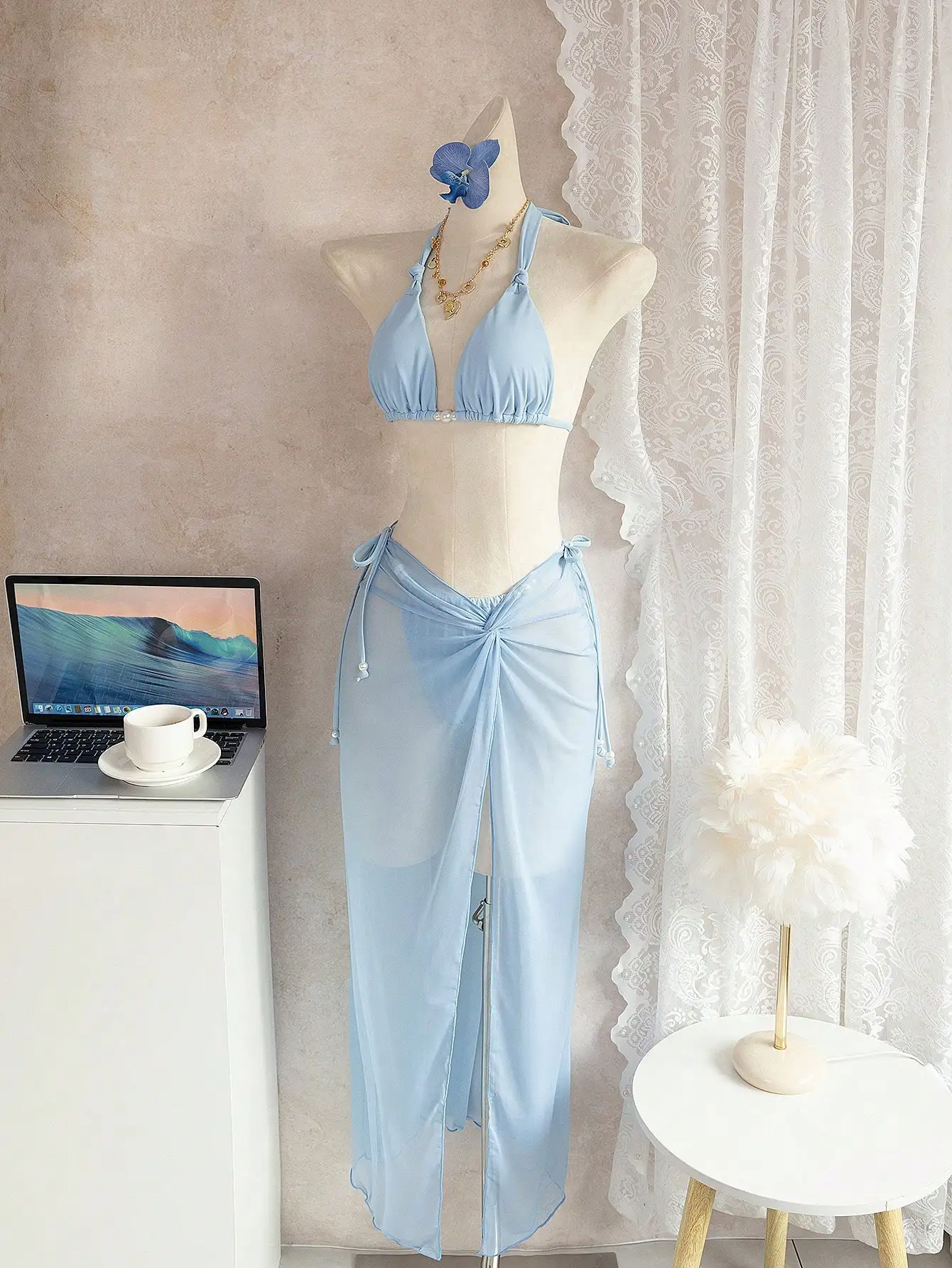 

Светло-голубой комплект бикини с прозрачной юбкой-накидкой, топом-халтером и жемчужными акцентами для пляжного отдыха