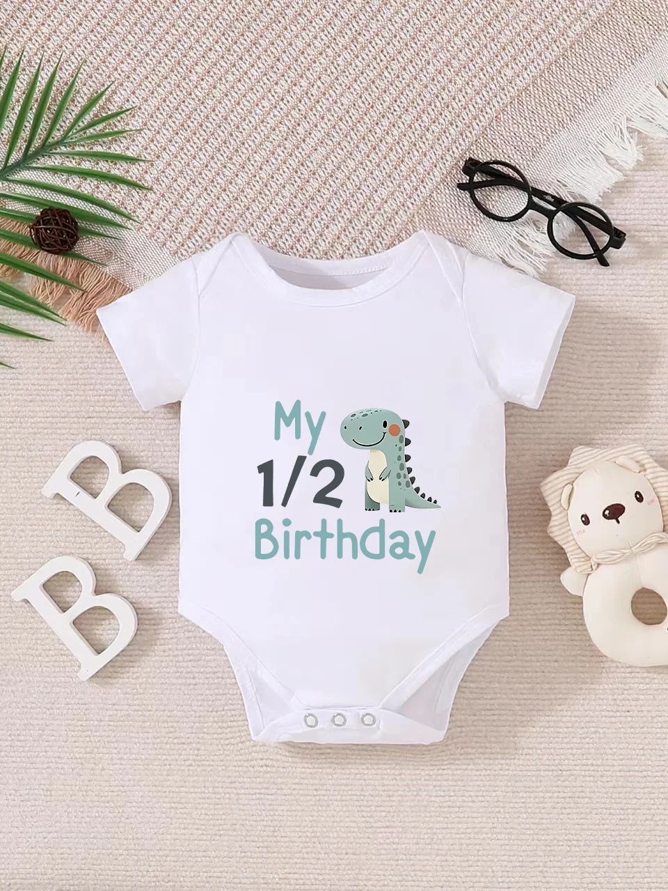 Playful letter-printed baby short-sleeve triangle bodysuit. Button closure for easy dressing, machine washable