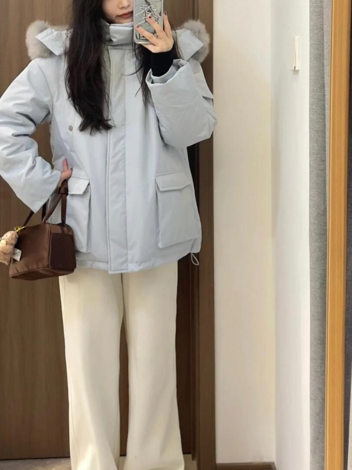 เสื้อโค้ทพาร์กาผู้หญิงสีน้ำเงิน ผ้าฝ้ายผสมขนเป็ด ทรงยาวปานกลาง มีฮู้ด แต่งขนเฟอร์ที่ปกเสื้อ  สำหรับฤดูหนาว เหมาะสำหรับใส่เดินทาง