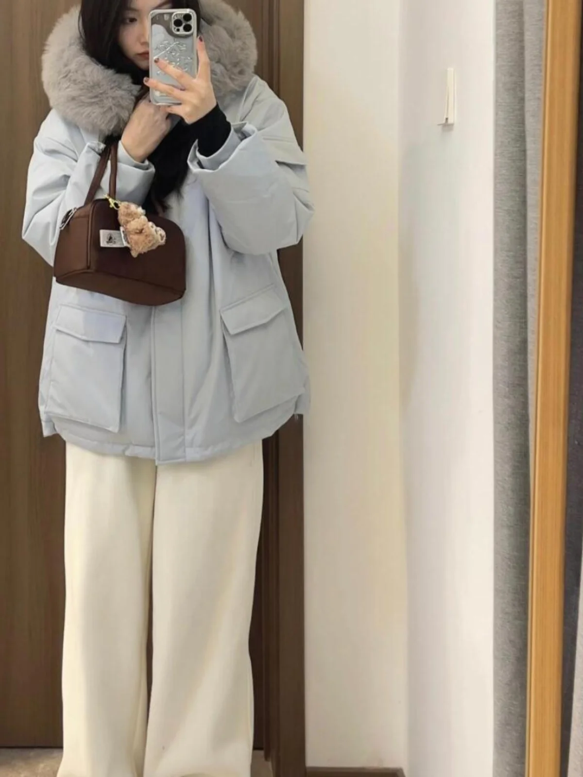 เสื้อโค้ทพาร์กาผู้หญิงสีน้ำเงิน ผ้าฝ้ายผสมขนเป็ด ทรงยาวปานกลาง มีฮู้ด แต่งขนเฟอร์ที่ปกเสื้อ  สำหรับฤดูหนาว เหมาะสำหรับใส่เดินทาง