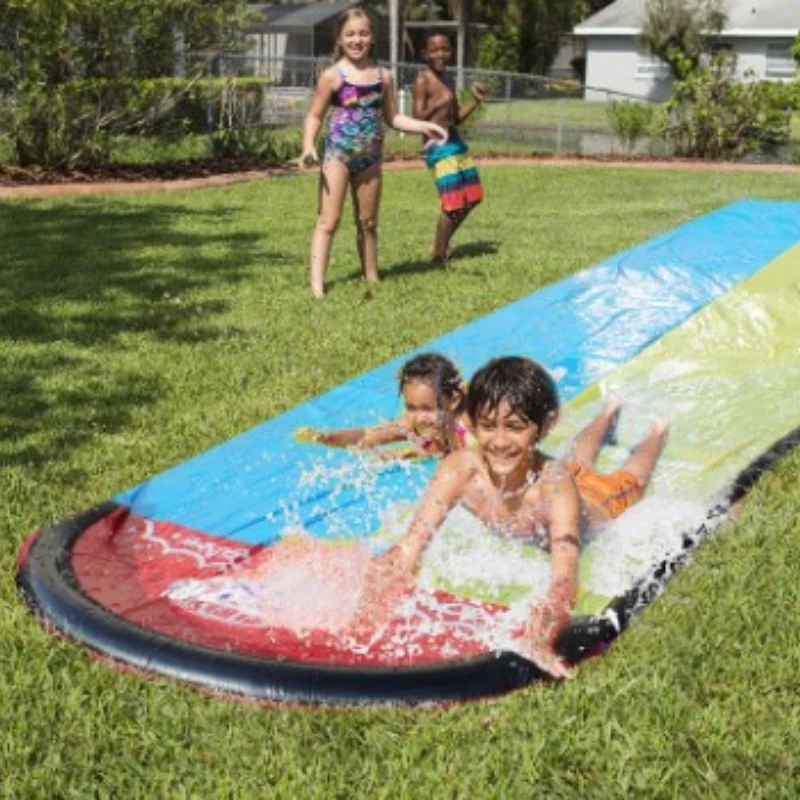 Children Play with Water Toys and Water Skiing Watercourses in Summer Children Play with Water in the Lawn Courtyard in Pairs