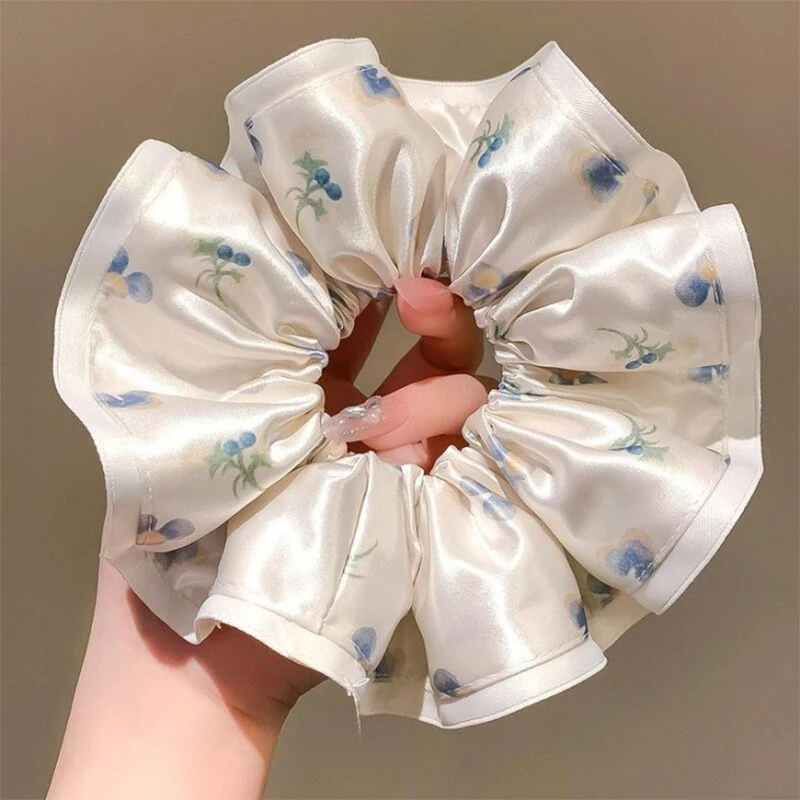 Une élastique à cheveux florale délicate, un élastique à cheveux sophistiqué pour queue de cheval, un accessoire de coiffure élégant, un accessoire de coiffure pour chignon, et une élastique à cheveux.