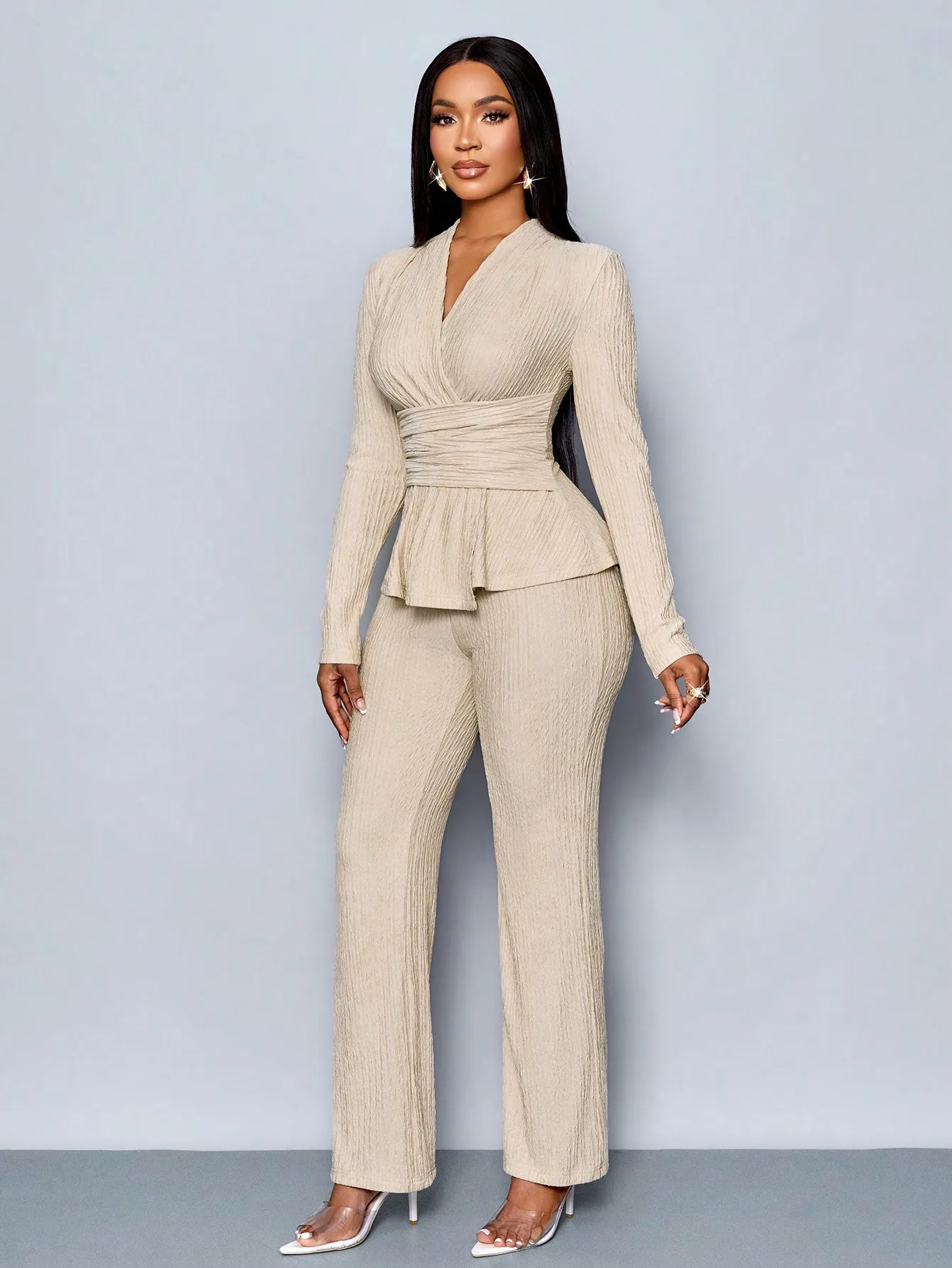 Top a maniche lunghe con scollo a V beige e pantaloni a gamba larga, completo due pezzi da donna, elegante outfit casual.