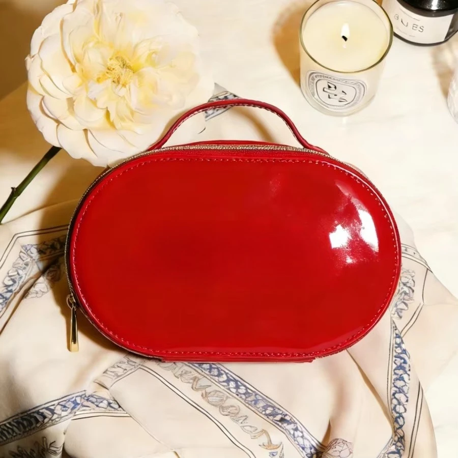 Luxury Glossy Bright Red Oval Handheld Makeup Storage Bag Patent Leather Embossed Logo Waterproof Travel Cosmetic Bag