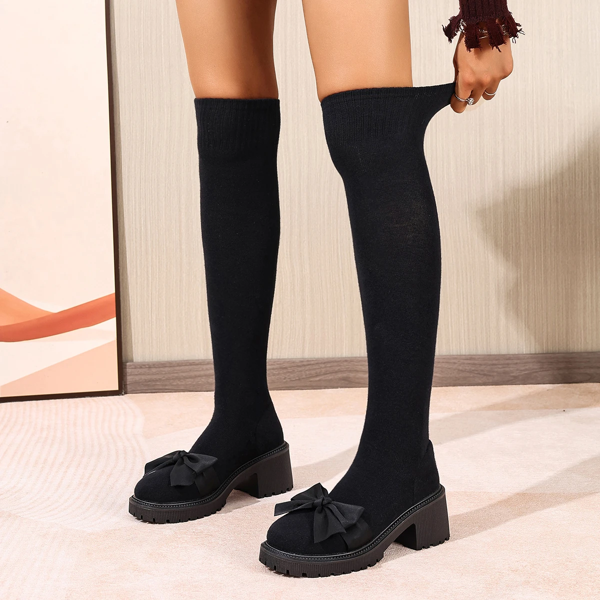

Осенние сапоги на высоком каблуке. Женские модные сапоги выше колена на платформе и массивном каблуке. Черные эластичные сапоги с лентой и бантом. Женская обувь.