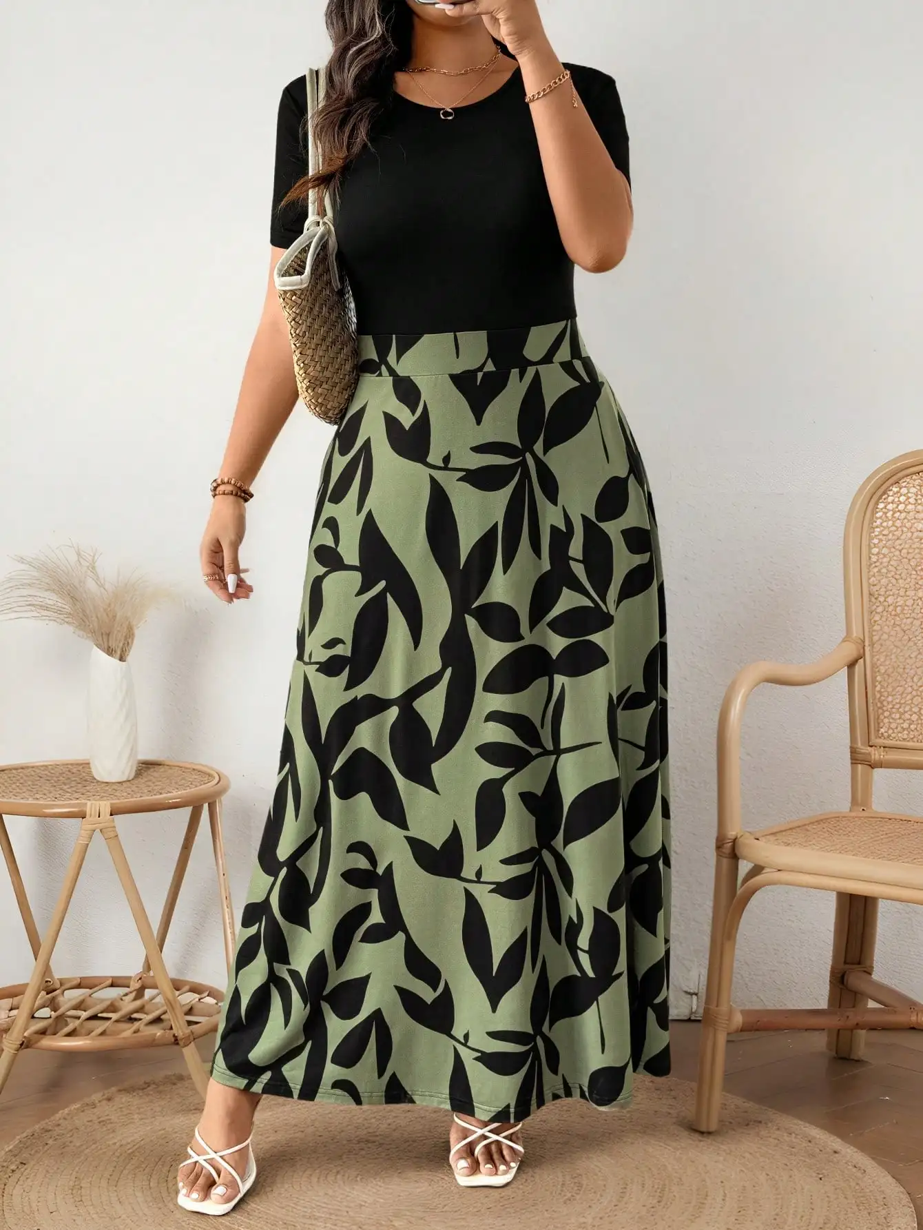 

Оливково-зеленое платье макси с принтом в виде листьев, с черными контрастными вставками, из трикотажной ткани, свободного кроя.