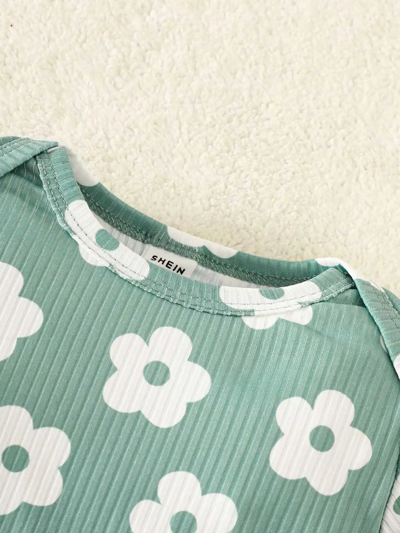 Grünes Set aus langärmligem Strampler mit Rundhalsausschnitt und kleinem Blumenmuster sowie einer langärmligen Stramplerhose mit süßem Blumenmuster für Babys. – Detail 6