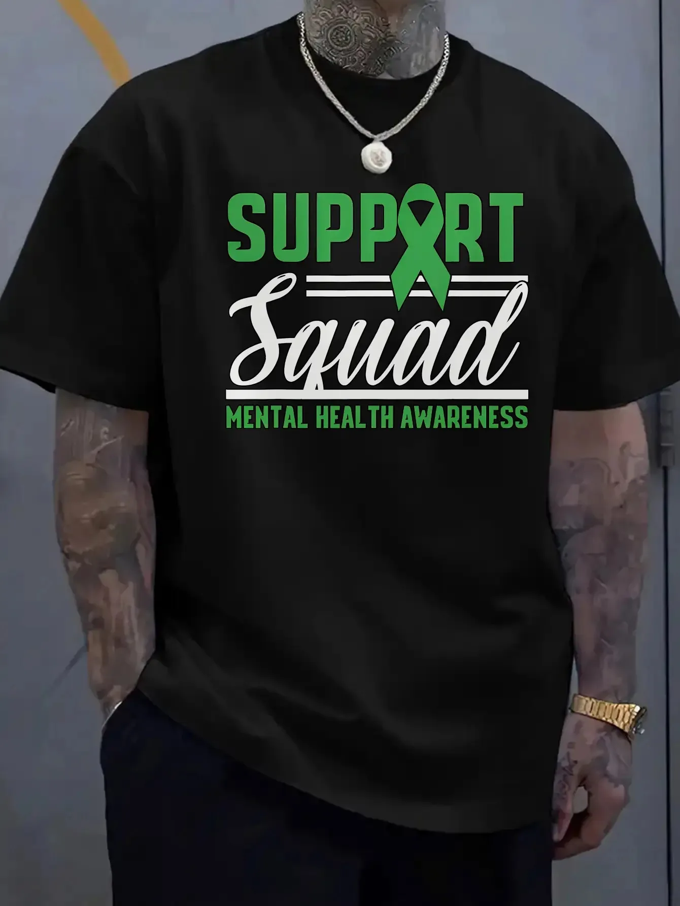 

A white T-shirt supporting the mental health awareness of the team men with a green ribbon and the team slogan
