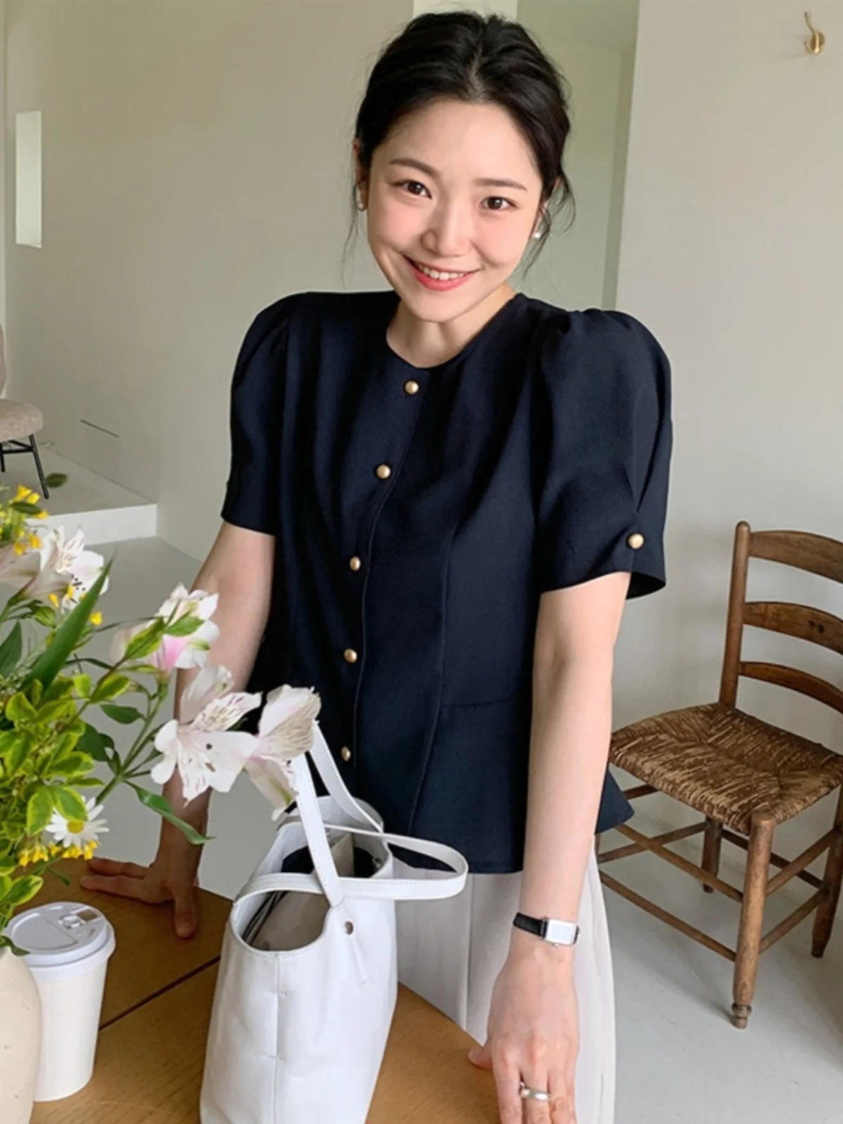 Elegancka damska sukienka w stylu vintage, delikatna, z pojedynczym guzikiem, bufiaste rękawy, podkreślona w talii, o długości midi, z kwiatowym wykończeniem.