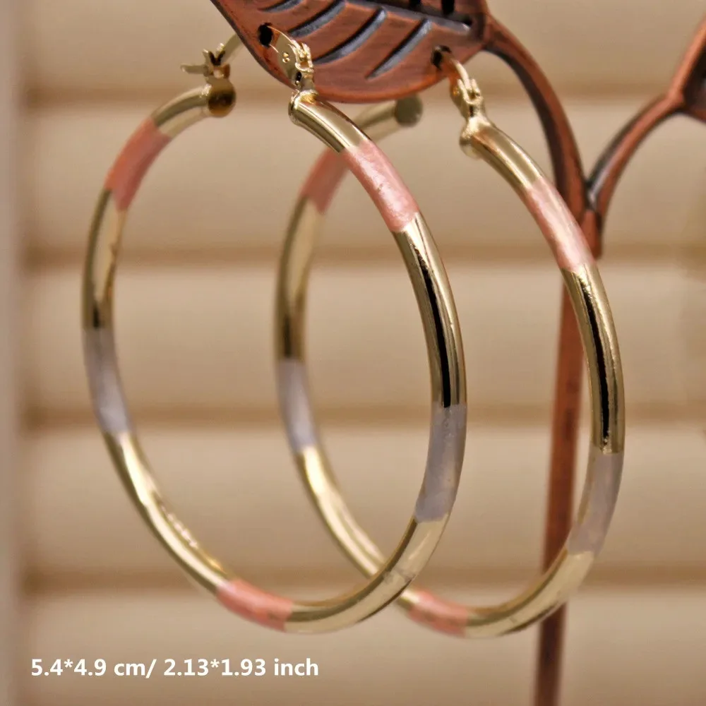 Fashionable women's earrings made of vintage copper, with a golden large hoop and twisted ear wire