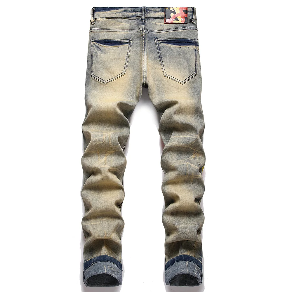 Jeans in Denim elasticizzato da uomo con stampa Streetwear personaggio teschio dipinto a fiamma pantaloni Vintage bottoni pantaloni sottili strappati