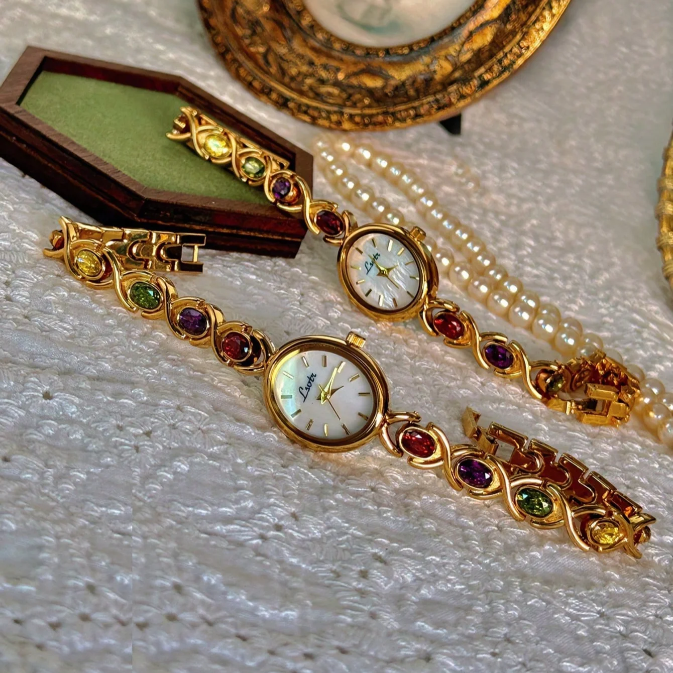 A lady's watch with colorful tourmaline, diamond and oval mother's pearl dial.