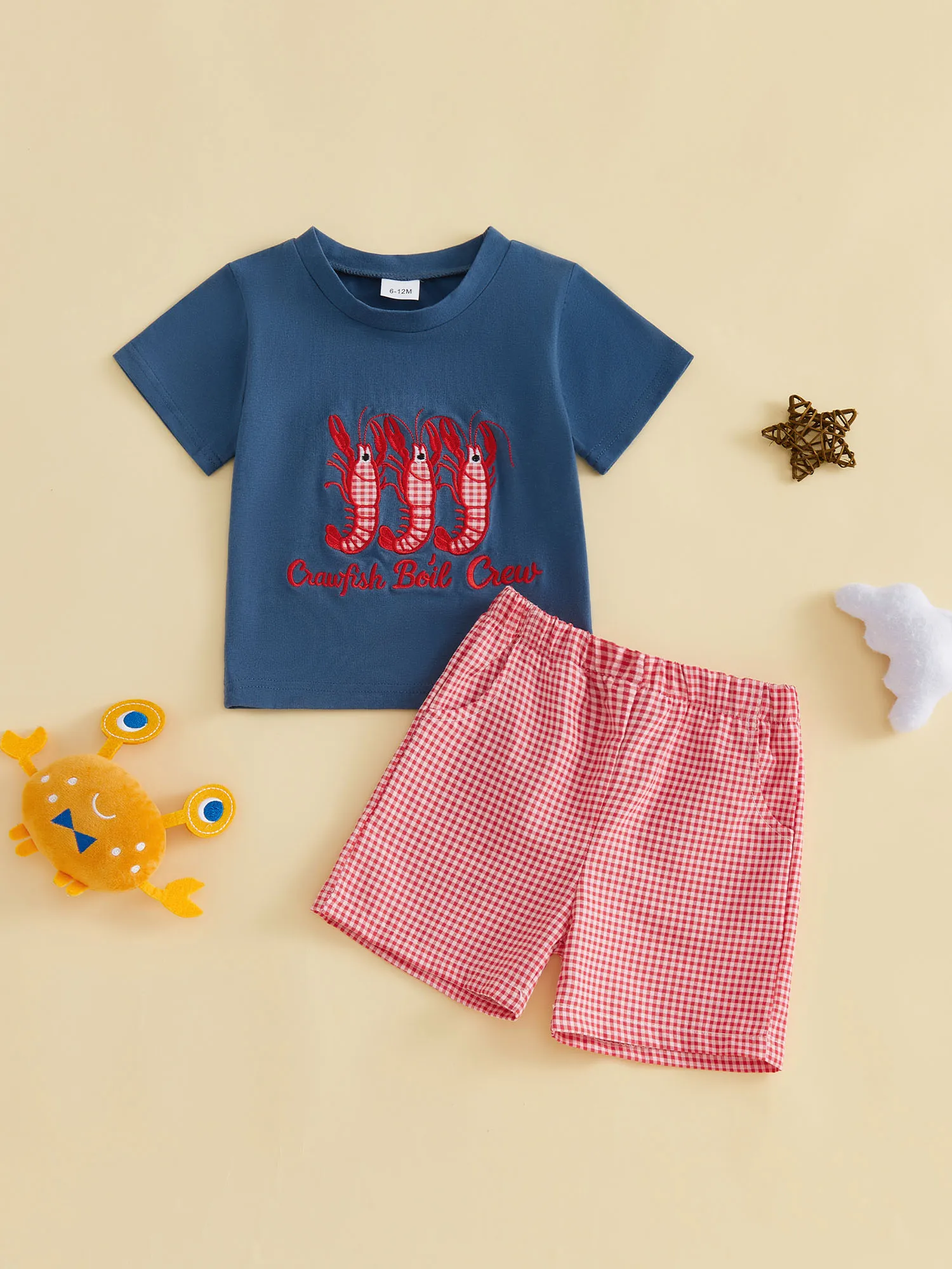 

Очаровательный летний наряд для малышей: стильная футболка с аппликацией в виде краба в сочетании с клетчатыми шортами — милый комплект из двух предметов.