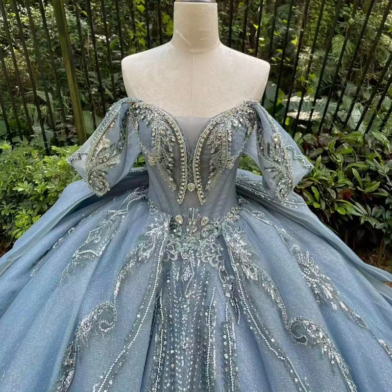 فساتين Quinceanera باللون الأزرق الفاتح اللامع ثوب حفلة قبالة الكتف مزين بالدانتيل مطرز بفيونكة مشد متدرج تول حفلة عيد ميلاد سوي