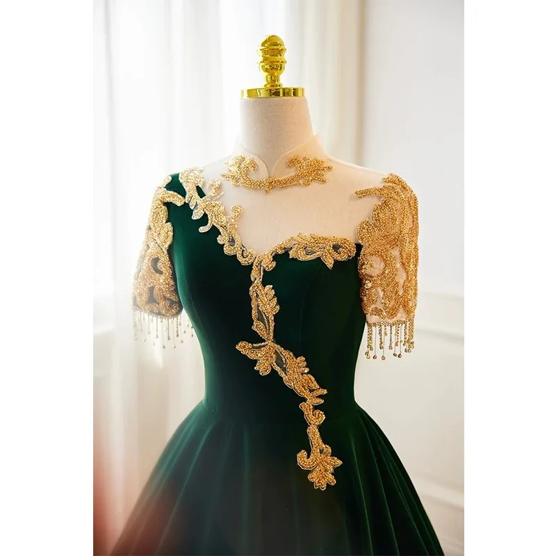 Ciemnozielona suknia wieczorowa, damska suknia na występ fortepianowy, elegancka atmosfera, wyszukana suknia do występów folkowych.