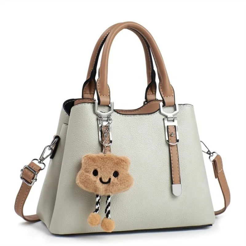 

Элегантная женская сумка с кисточками, украшенная подвесными акцентами и мягким кожаным материалом