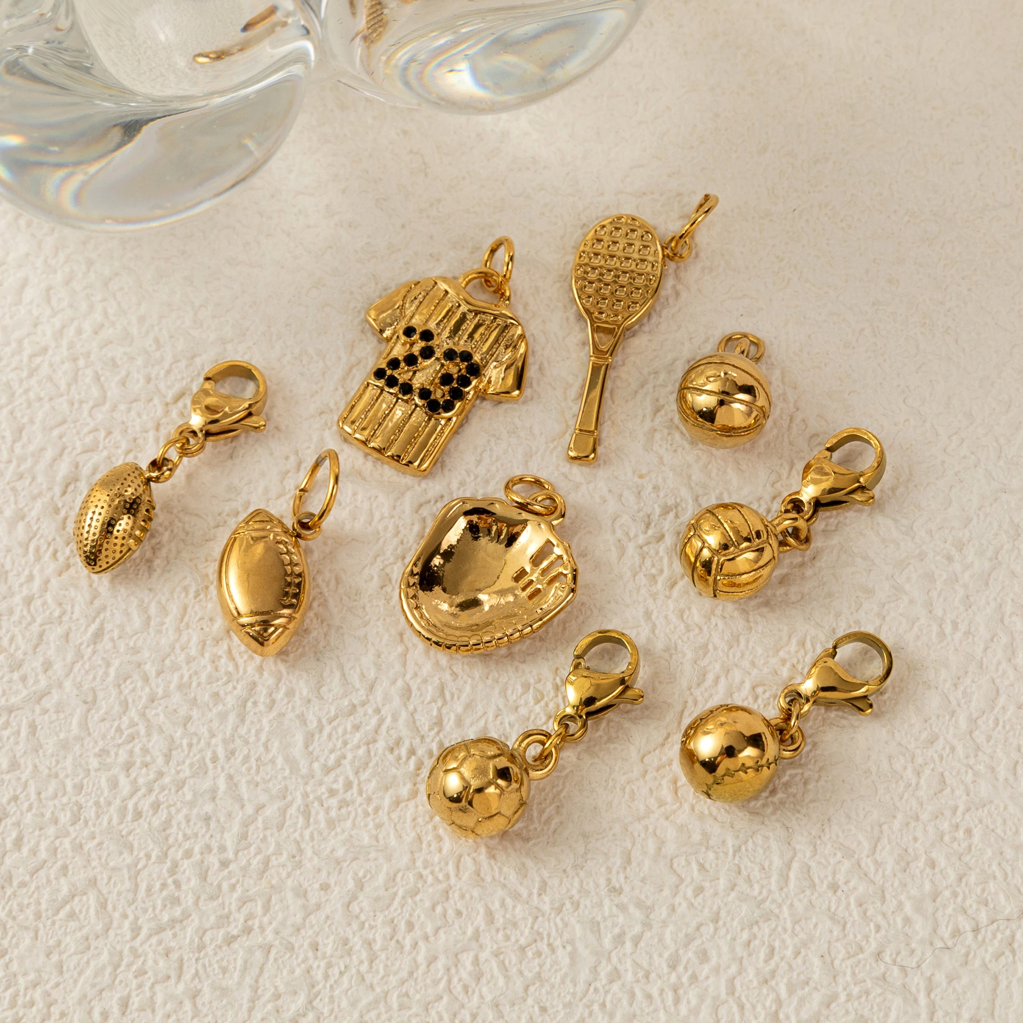 

Stainless steel sports series pendant, racket, football basketball, rugby, sports jersey pendant, gold-plated color retention