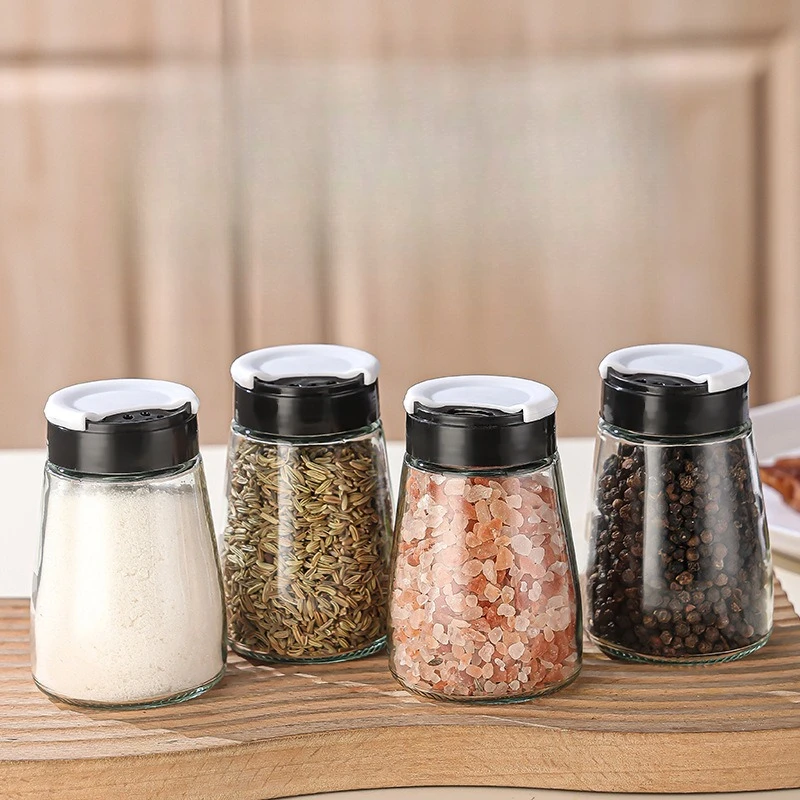 Una botella de vidrio transparente de plástico para barbacoa de cocina, pimiento y condimentos para cominos, rociadores y polvos