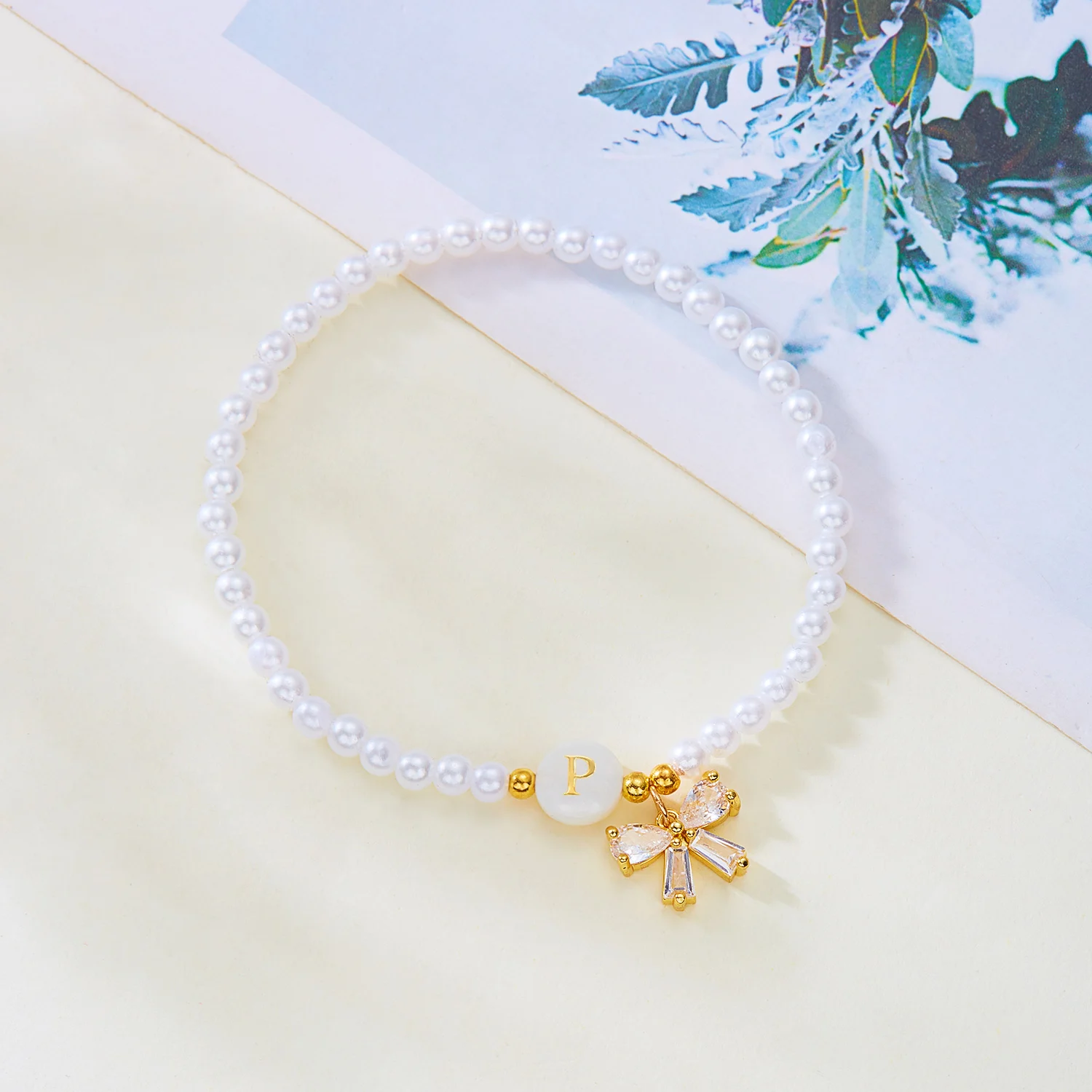 Zierliches Armband mit Imitationsperlen und 26 Buchstaben-Initialen für Damen, Luxuriöses Zirkon-Schleifenanhänger-Armband, Handgelenk-Schmuckgeschenk – Detail 11