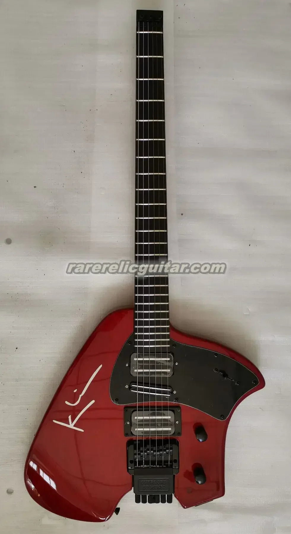 2025 En stock Guitarra eléctrica sin cabeza roja Klein Trans - Cuerpo de caoba, trémolo de brazo vibrato, pastilla HSH, golpeador negro
