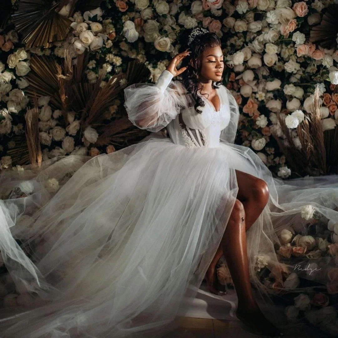 Suknia ślubna w kształcie litery A z dekoltem w serek, tiulowa, z długimi rękawami typu lampion, prześwitująca, z rozcięciem, idealna na przyjęcie weselne.