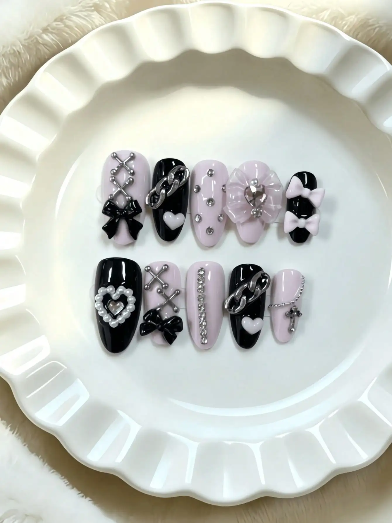 10 faux ongles en forme d'amande, de longueur moyenne, noirs et roses contrastés, dans un style subculture doux et cool, avec des chaînes métalliques, des nœuds 3D et des strass en forme de cœur, avec des couleurs contrastées noires et roses et des techniques de décoration métallique, adaptés aux filles stylées et aux femmes branchées, parfaits pour les festivals de musique, les sorties en ville et les événements de niche, livrés avec de la colle gel et une lime à ongles.