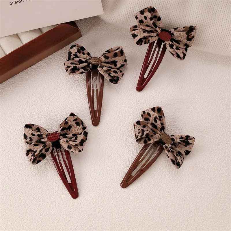 2pcs leopard print bow-shaped hairpin for girls with side-bun and beach hairstyle, featuring a new and sweet hairpin accessory