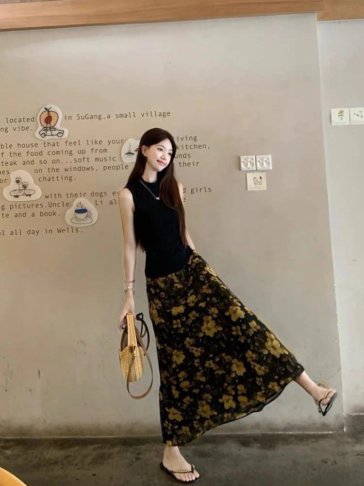 

Черный топ без рукавов с длинной юбкой с цветочным принтом. Женский летний модный комплект. Дизайн, стройнящий фигуру. Повседневный элегантный образ. ​