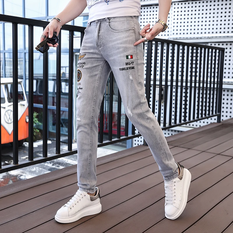 Street personality embroidery letters badge denim pants summer hole men's jeans light luxury fashion slim stretch pencil pants