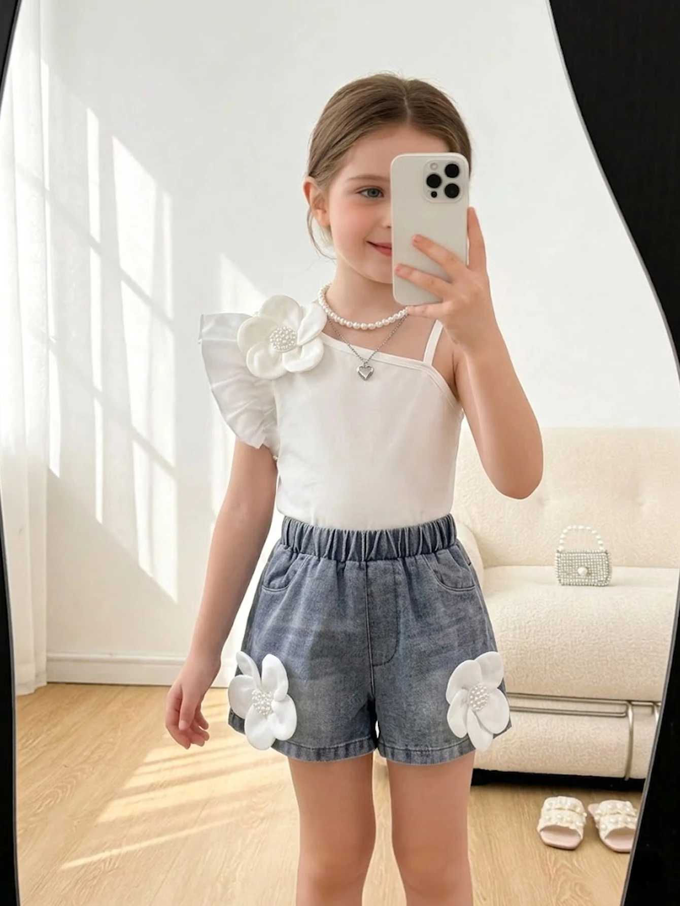 

Летний комплект для девочек: топ с цветочным принтом на одно плечо и рукавами-крылышками в сочетании с джинсовыми шортами для милых и непринужденных прогулок.