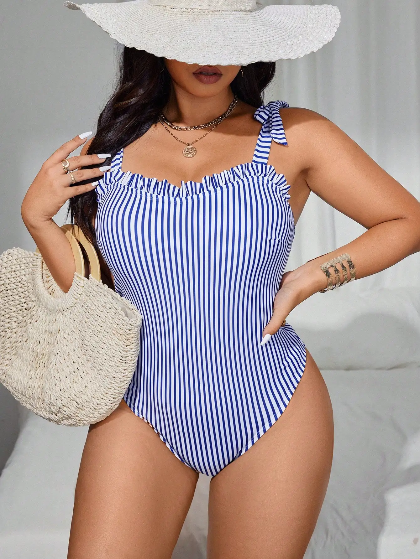 

Цельный купальник больших размеров сине-белого цвета в вертикальную полоску, с рюшами на груди и регулируемыми бретелями на завязках.