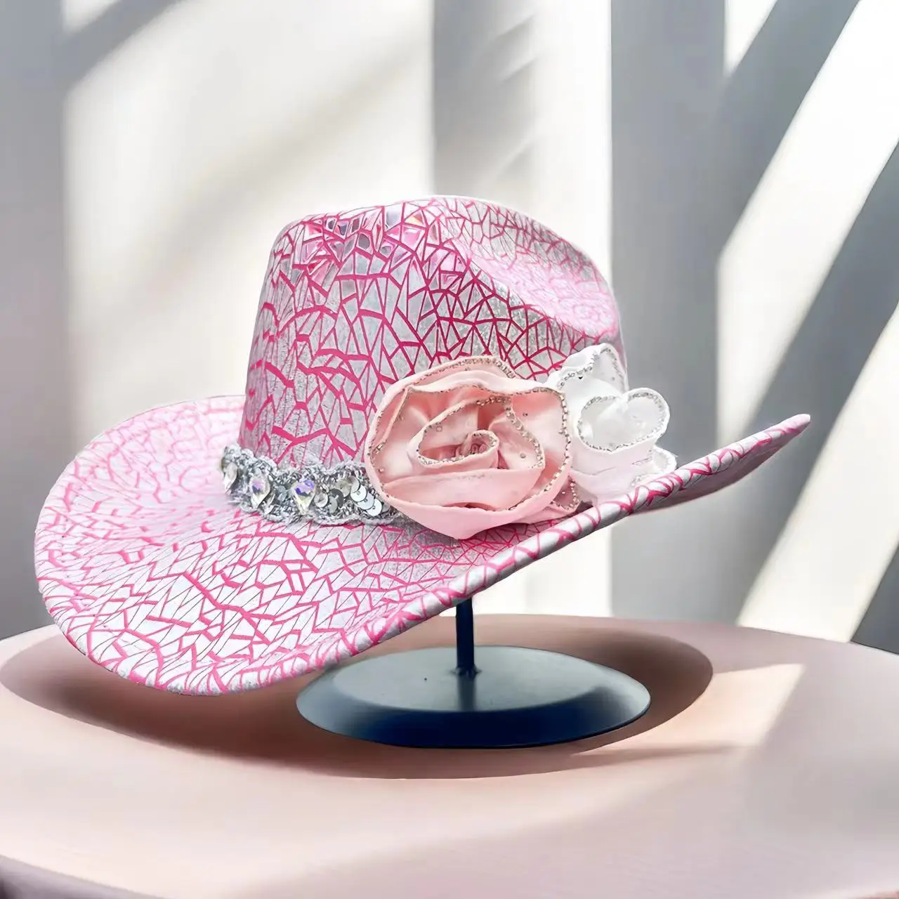 A pink cracked delicate rhinestone flower adorns a stylish top hat for bachelorette parties, adult parties, bars