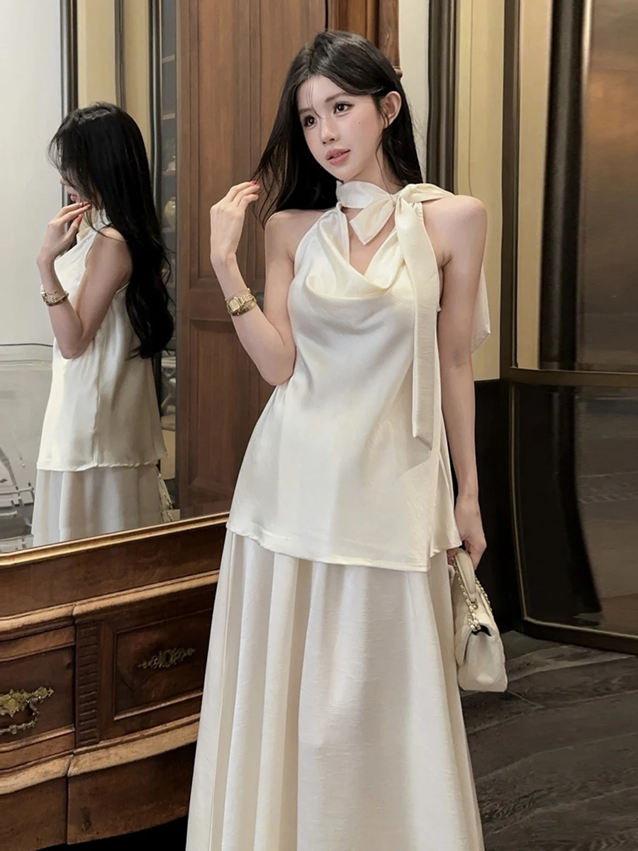 

Элегантный комплект из атласной блузки без рукавов и юбки миди для женщин: свободный крой, французский стиль, модный дизайн, стройнящий силуэт