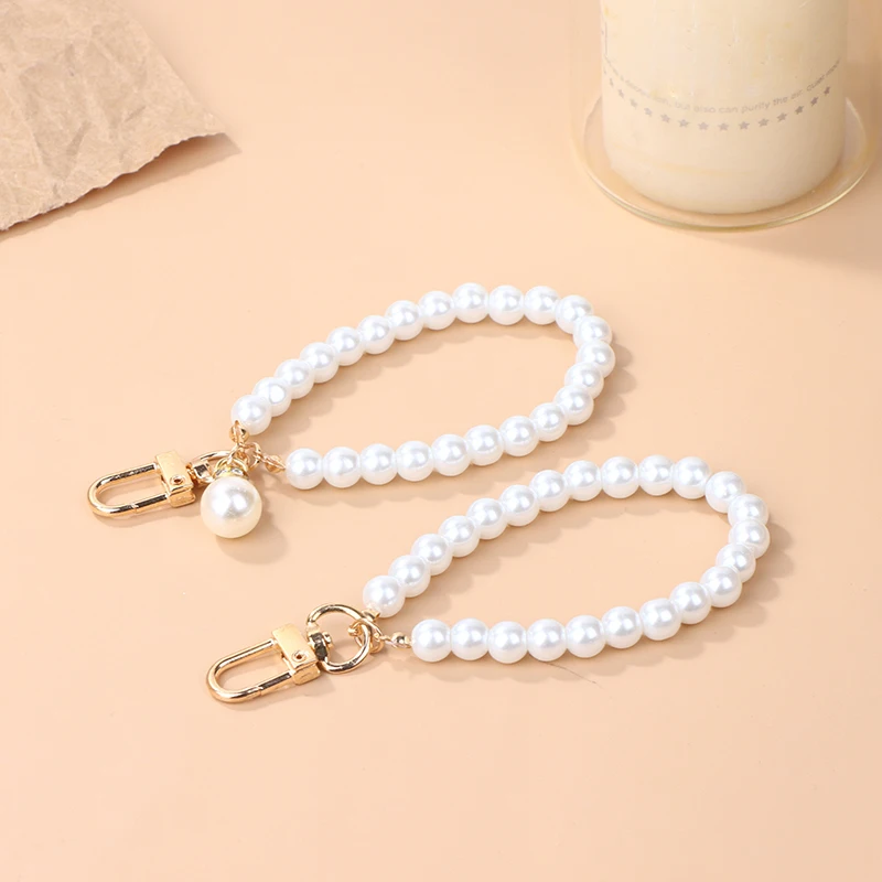 LLavero de perlas de imitación para mujer, colgante de bolso de auriculares, llavero de pulsera con cuentas de perlas, adorno para teléfono móvil