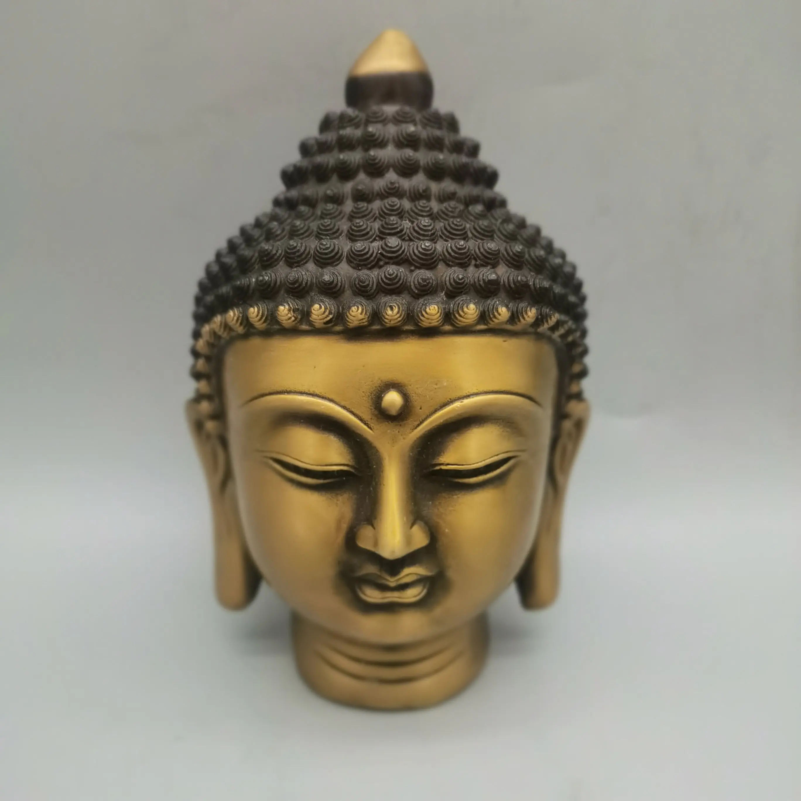 

A traditional Chinese pure copper statue of the Buddha Sakyamuni's head for home feng shui study and office desktop decoration