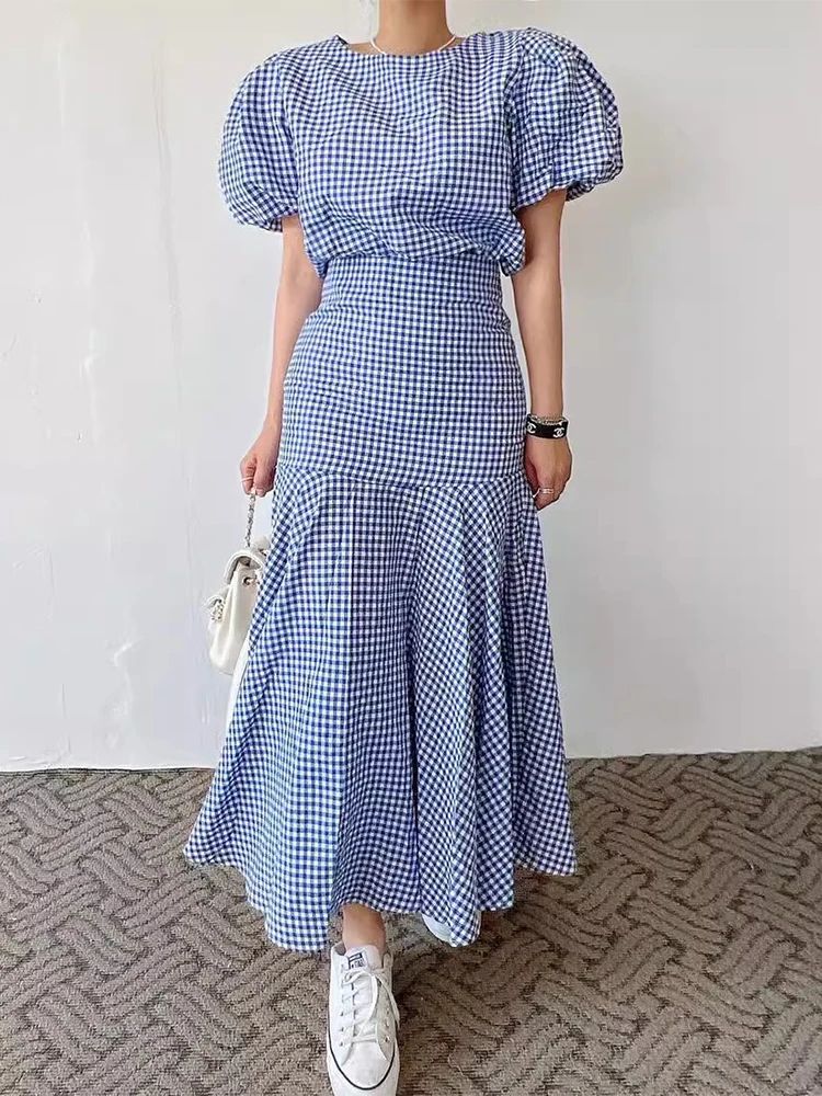 

Шикарный летний винтажный комплект из двух предметов: рубашка с пышными рукавами в клетку и юбка А-силуэта с высокой талией. Модный женский ансамбль.