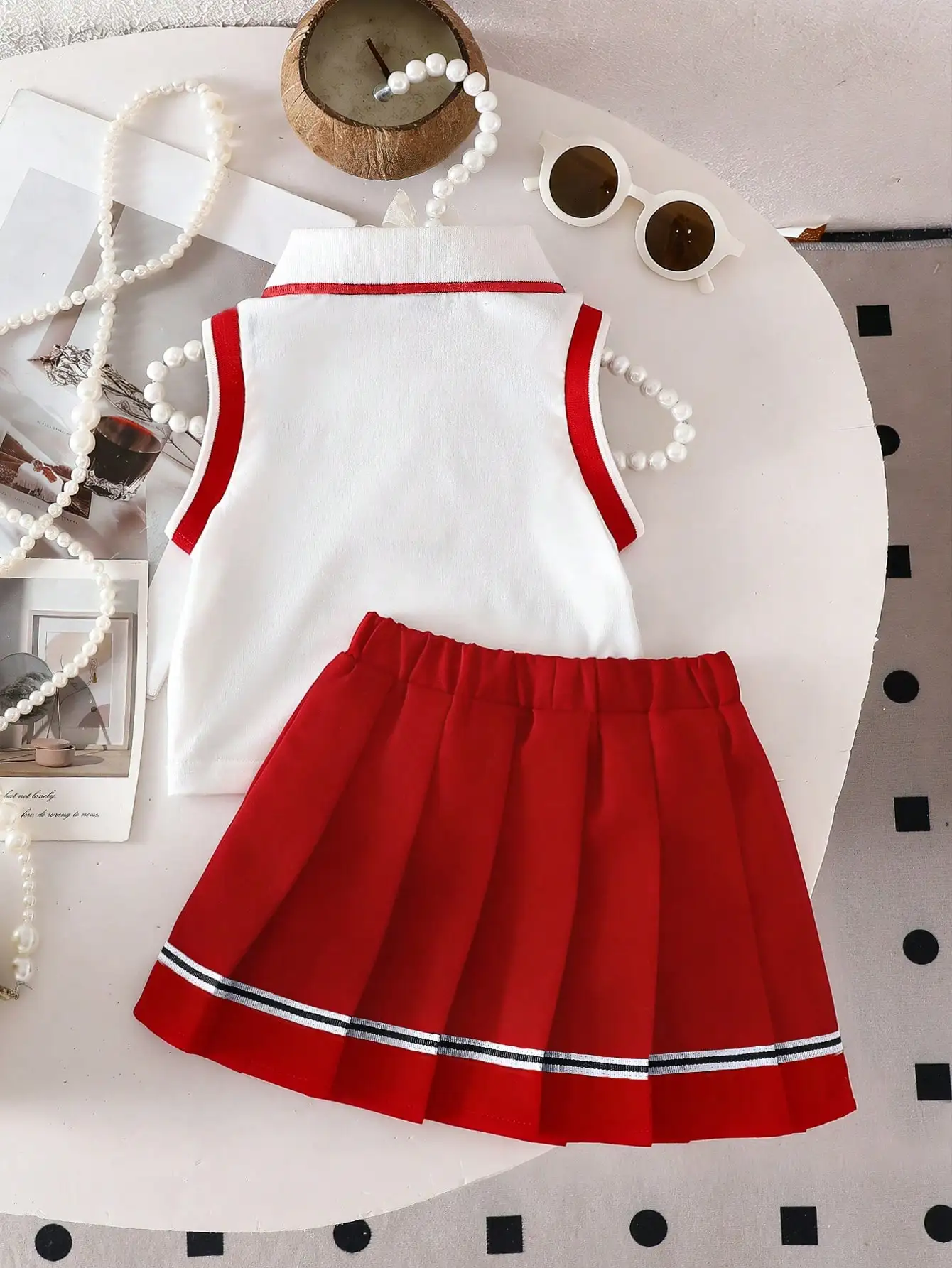 Zweiteiliges Set für Babys: ärmelloses Oberteil mit herzbesticktem POLO-Kragen und gewebter, lässiger, plissierter kurzer Rock im süßen und coolen Stil. – Detail 3