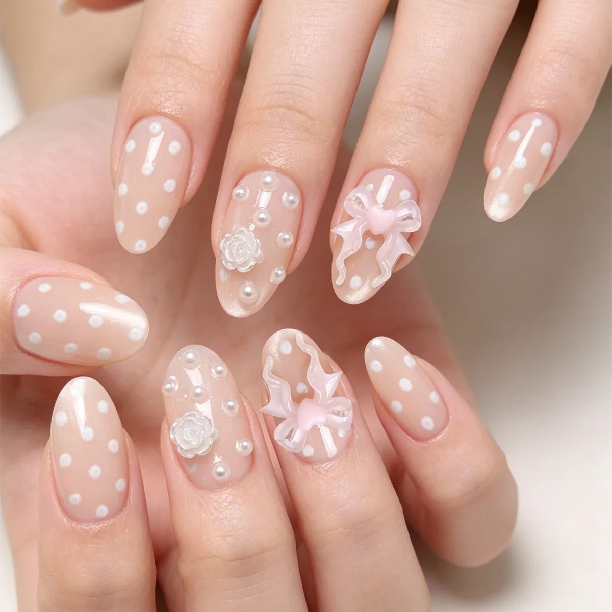 

24 soft nude polka dot nails with a 3D bow and pearl inspired base makeup, perfect for picnics, garden parties, and soft outdoor activities for women