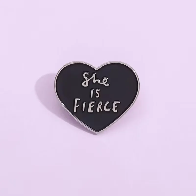 Pin de esmalte de corazón negro con cita en inglés, She is fierce broche de, accesorio de solapa para bolso, insignia, regalo para Amiga, joyería al por mayor