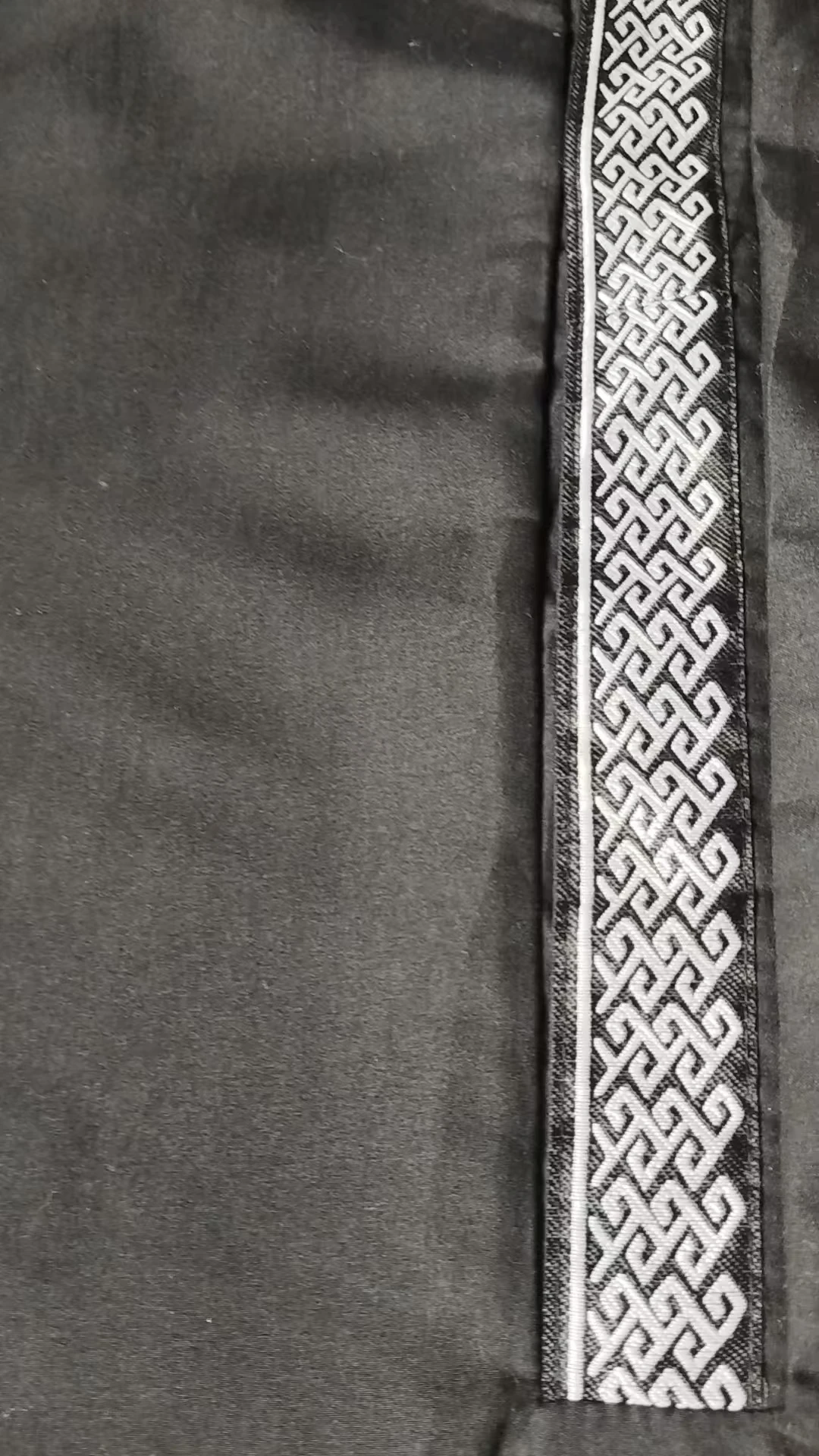 Un abito arabo nero in pizzo stampato bianco, un abito musulmano del Ramadan