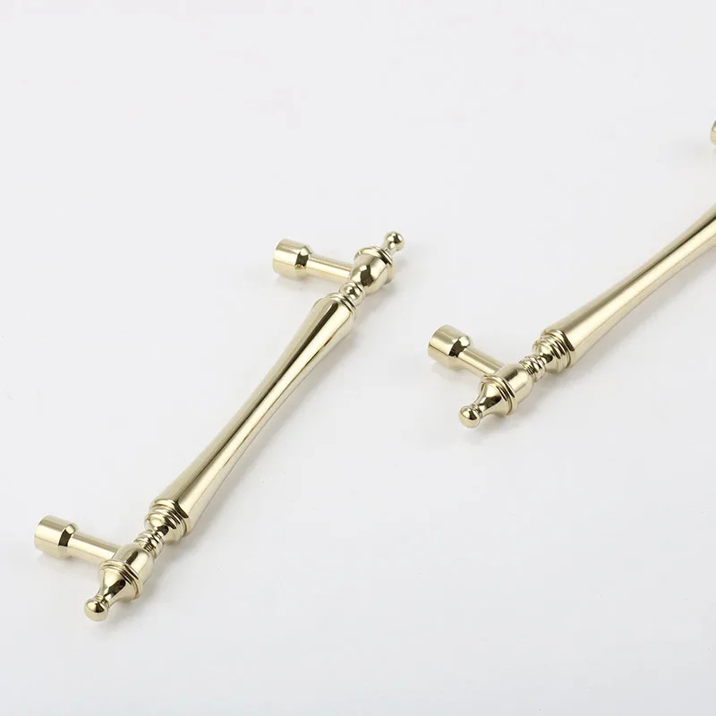Two gold bar pulls with matching mounting feet