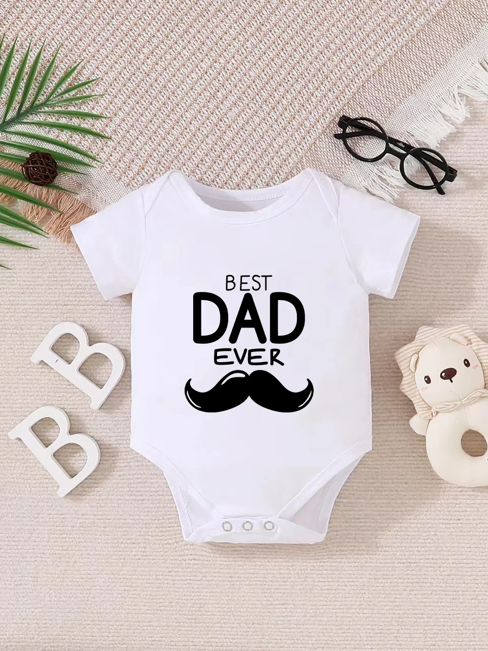 Playful letter-printed baby short-sleeve triangle bodysuit. Button closure for easy dressing, machine washable