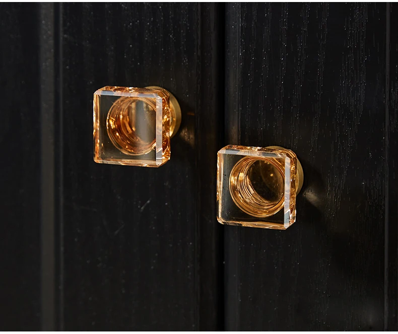 Square champagne glass knobs fitted to dark furniture
