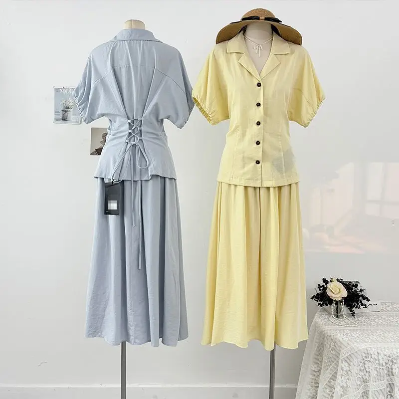 

Корейский стиль: дизайнерская рубашка с коротким рукавом, воротником-стойкой и шнуровкой сзади + юбка с высокой талией, свободного кроя, с широким подолом, элегантный комплект из двух предметов.